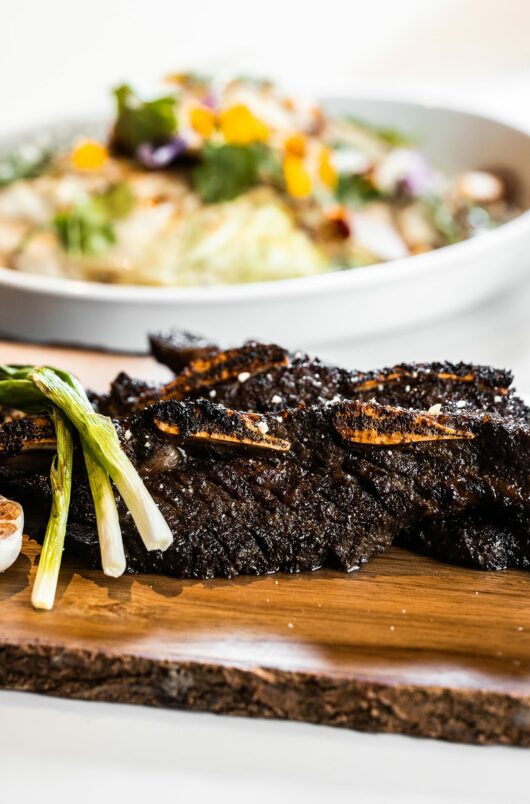 korean galbi short ribs prepared on table next to grilled cabbage side dish