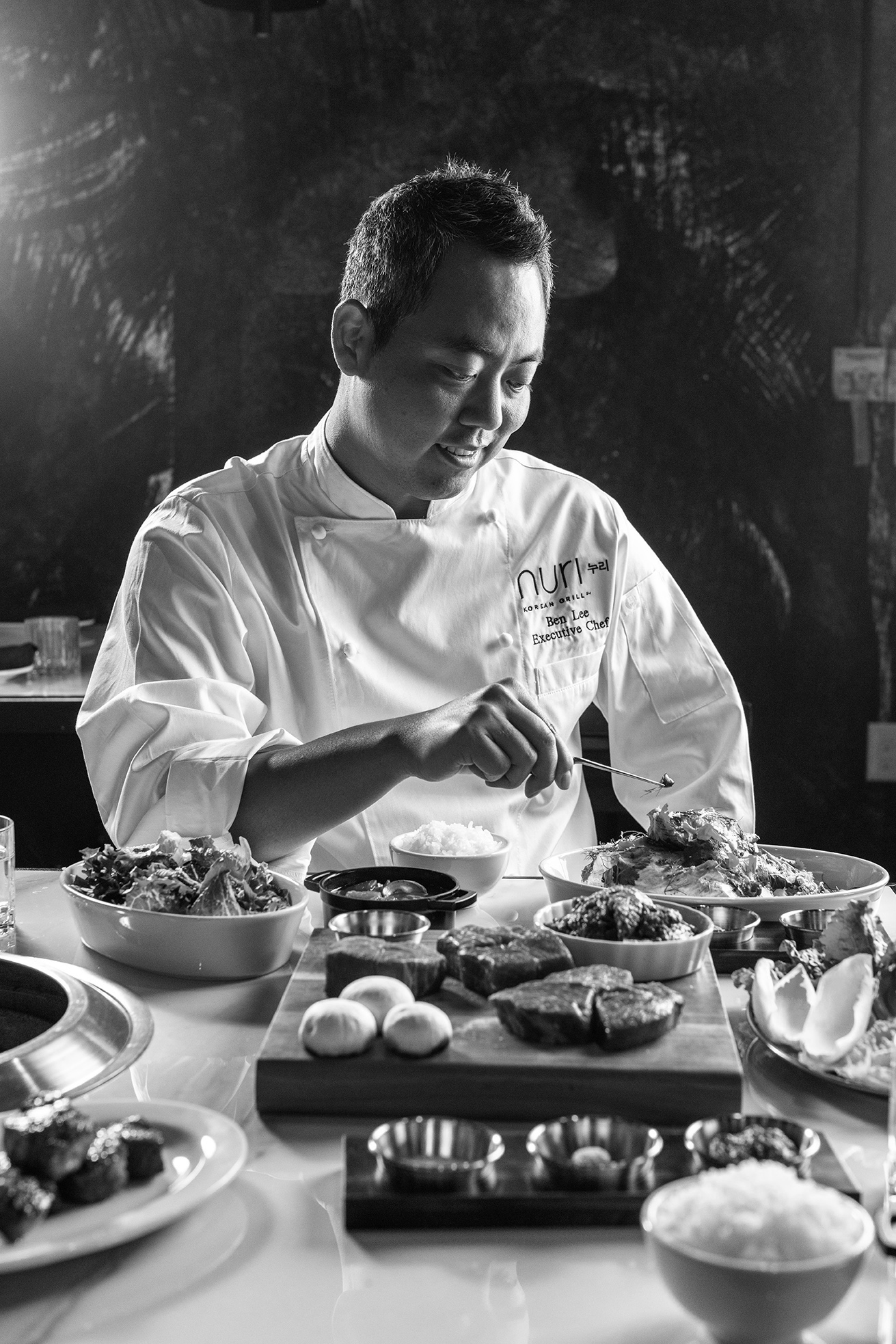 chef ben lee assembling multiple nuri dishes at table